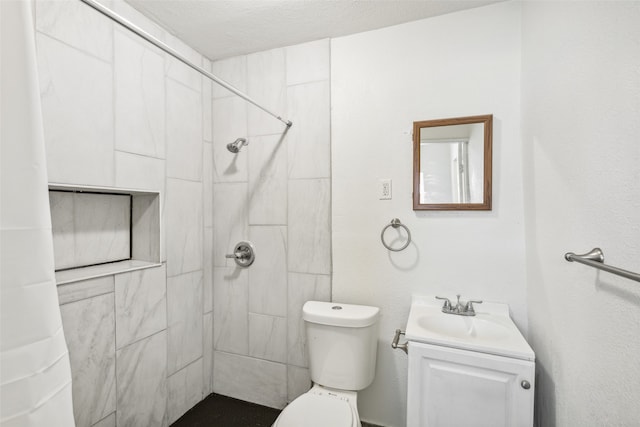 bathroom with vanity, a textured ceiling, curtained shower, and toilet