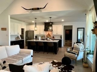 living room featuring vaulted ceiling and light wood-type flooring