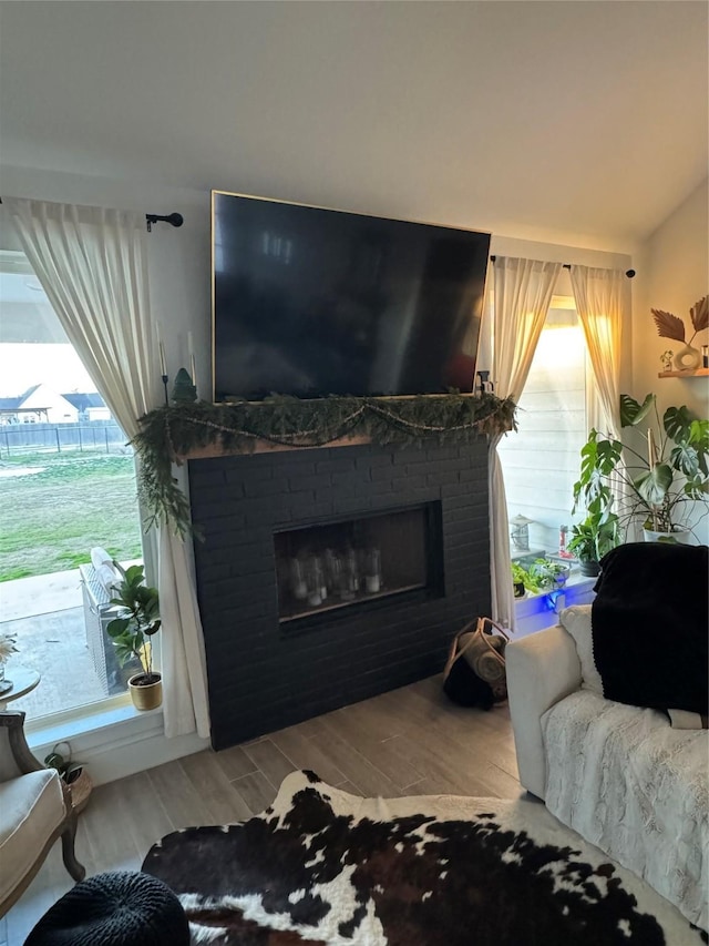 living room featuring a fireplace, lofted ceiling, and hardwood / wood-style flooring