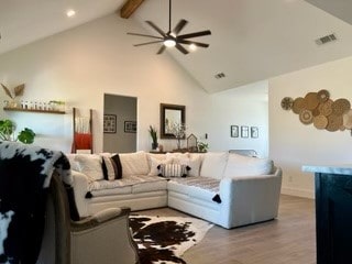 living room with ceiling fan, beam ceiling, light wood-type flooring, and high vaulted ceiling