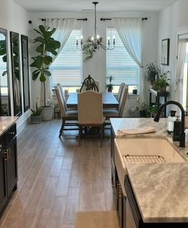 dining area featuring a chandelier, sink, and wood-type flooring