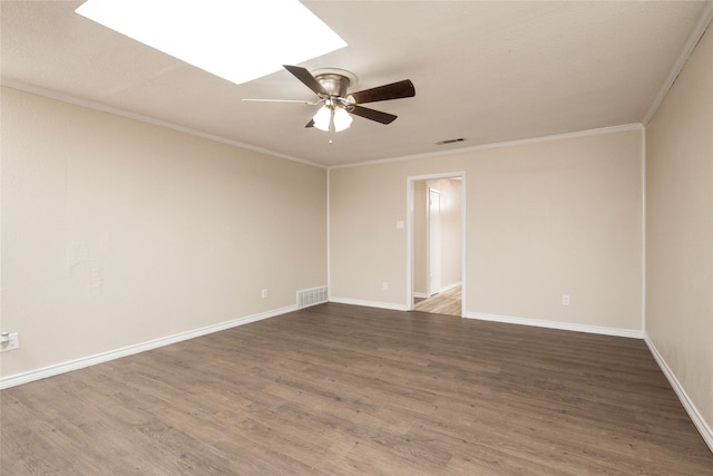 unfurnished room featuring ornamental molding, ceiling fan, dark hardwood / wood-style floors, and a skylight