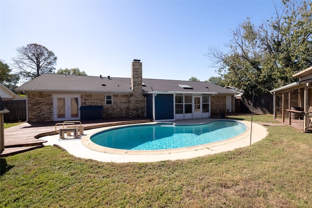 view of pool featuring french doors, a deck, and a yard