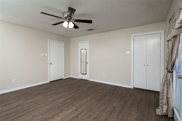 unfurnished bedroom featuring dark wood-type flooring, ceiling fan, and a textured ceiling