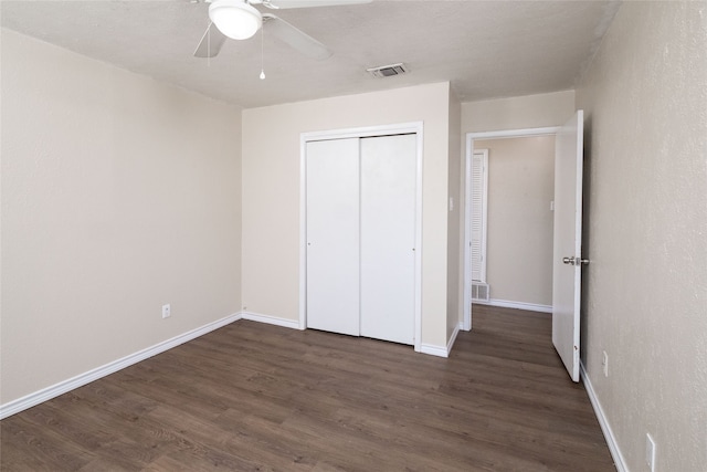 unfurnished bedroom featuring a closet, dark hardwood / wood-style floors, and ceiling fan