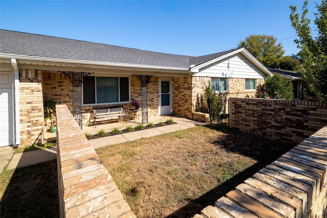 ranch-style house featuring covered porch and a garage