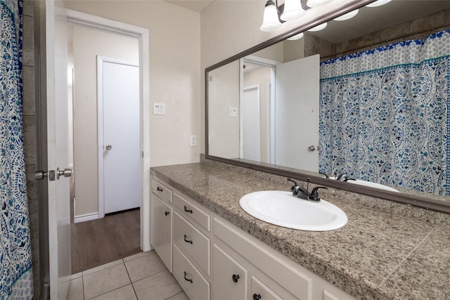 bathroom with walk in shower, vanity, and tile patterned floors