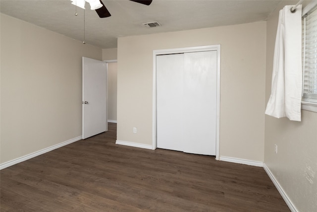 unfurnished bedroom featuring dark hardwood / wood-style flooring, a closet, and ceiling fan