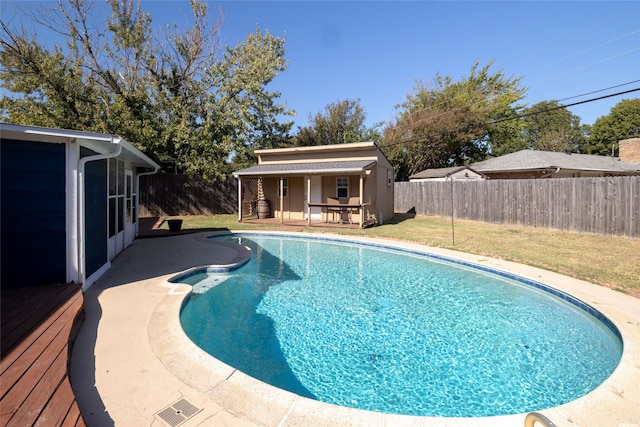 view of pool with a yard and an outbuilding