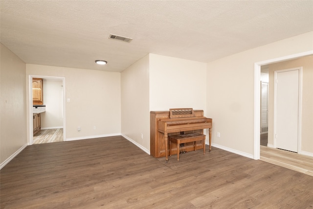 miscellaneous room with a textured ceiling and light hardwood / wood-style floors