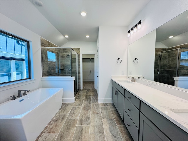 bathroom featuring vanity, separate shower and tub, and vaulted ceiling