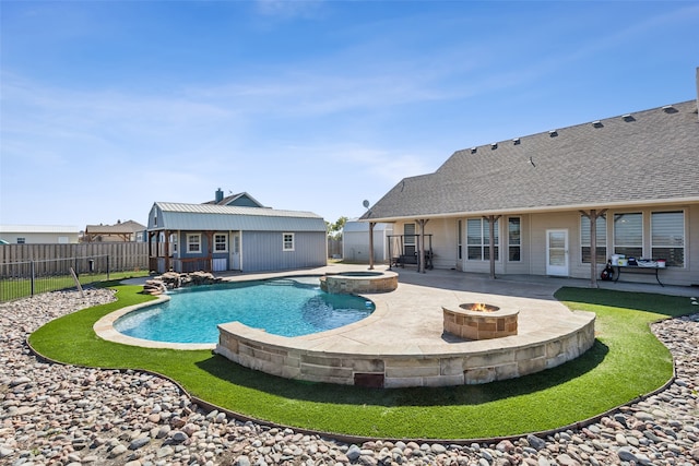 view of swimming pool featuring an outbuilding, an in ground hot tub, a patio, and a fire pit