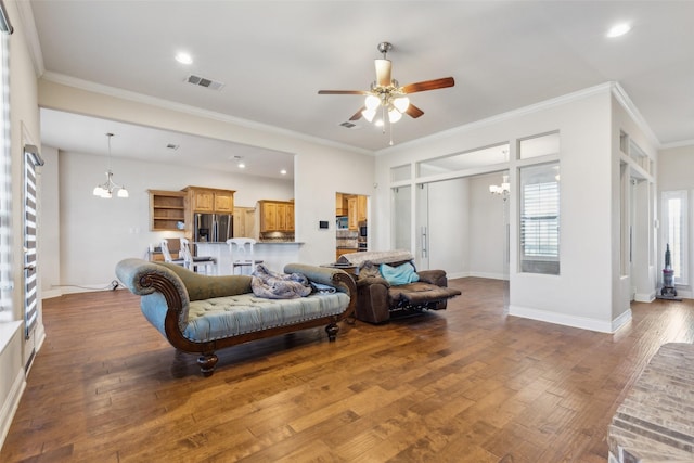 living room with ceiling fan with notable chandelier, dark hardwood / wood-style floors, and crown molding