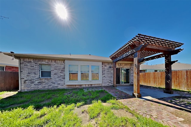 rear view of house with a patio, a yard, and a pergola