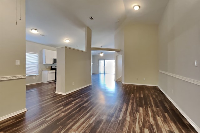 unfurnished living room featuring dark wood-type flooring and ceiling fan