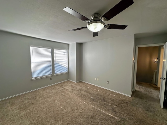 carpeted spare room featuring ceiling fan