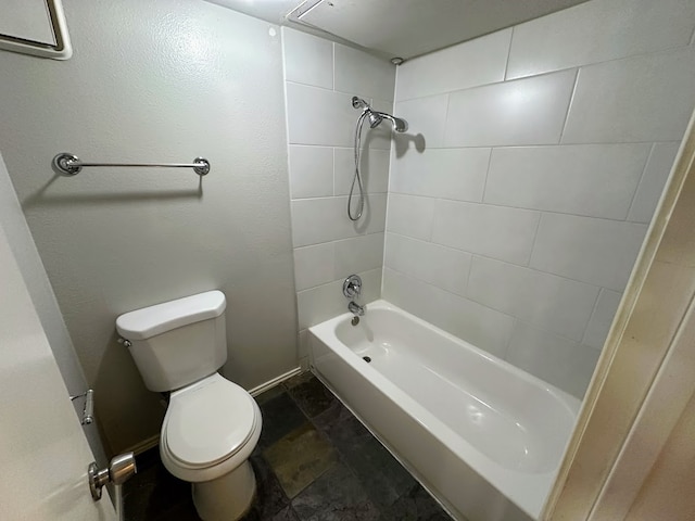 bathroom featuring tiled shower / bath and toilet