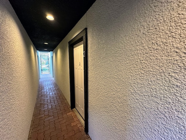 hall featuring a textured ceiling