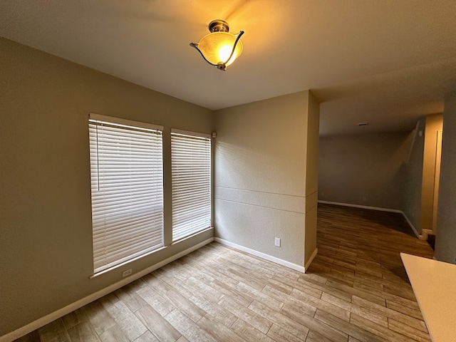 unfurnished room featuring a wealth of natural light and hardwood / wood-style floors