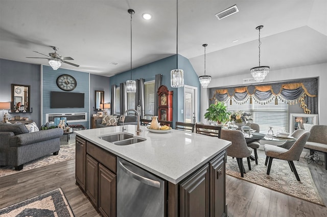 kitchen featuring lofted ceiling, dark hardwood / wood-style flooring, a kitchen island with sink, stainless steel dishwasher, and sink