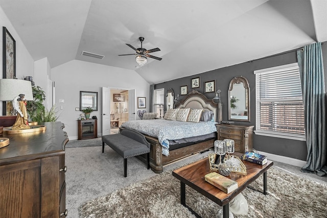 bedroom featuring light carpet, ensuite bathroom, ceiling fan, and vaulted ceiling