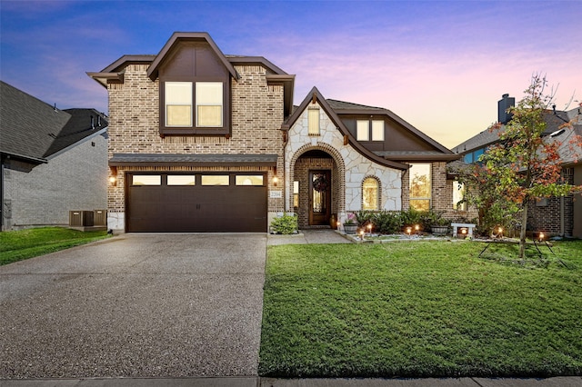 view of front facade featuring a lawn, cooling unit, and a garage