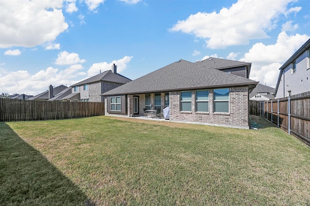 rear view of house with a yard and a patio