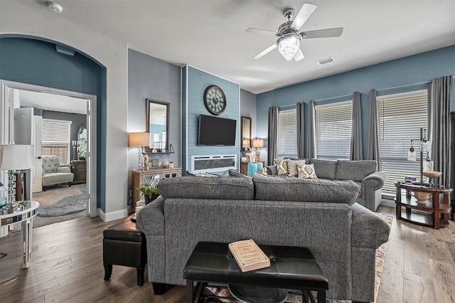 living room featuring a fireplace, hardwood / wood-style flooring, and ceiling fan