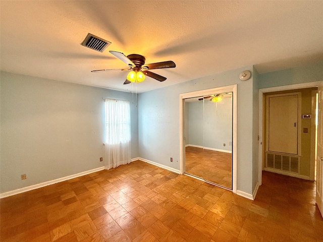 unfurnished bedroom with a textured ceiling, a closet, and ceiling fan