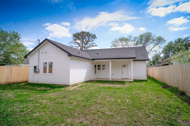 back of house with a yard and a patio