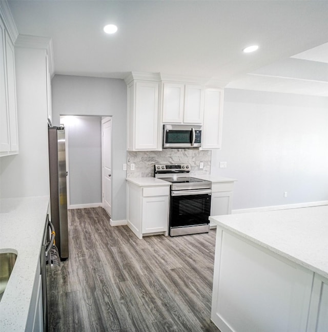 kitchen featuring decorative backsplash, white cabinets, stainless steel appliances, and light hardwood / wood-style floors