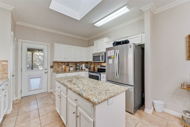 kitchen featuring tasteful backsplash, appliances with stainless steel finishes, a center island, and ornamental molding