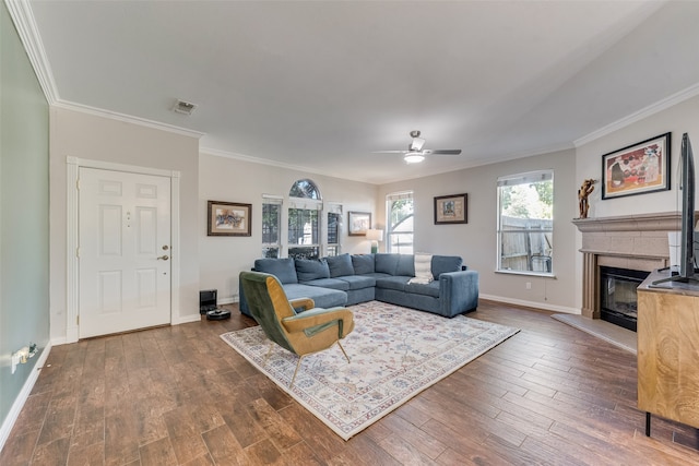 living room featuring dark wood-type flooring, crown molding, and ceiling fan