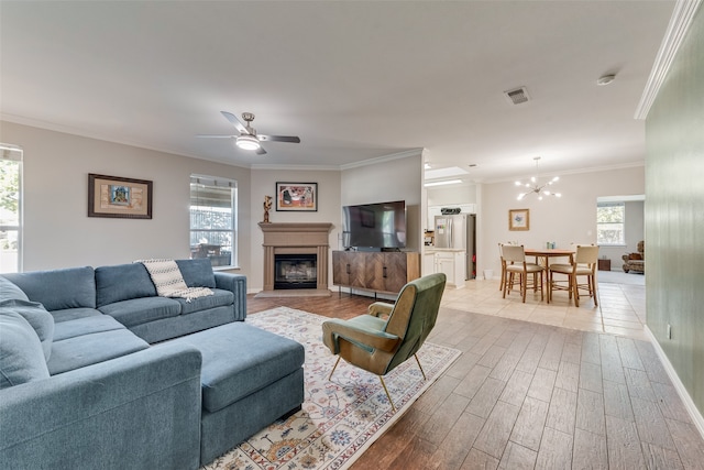 living room featuring light hardwood / wood-style flooring, a healthy amount of sunlight, and crown molding