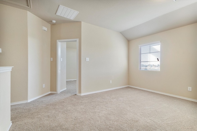 spare room with light carpet and lofted ceiling