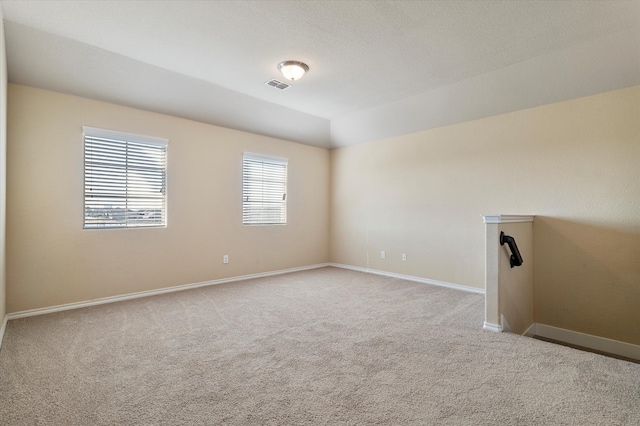 carpeted empty room featuring a textured ceiling