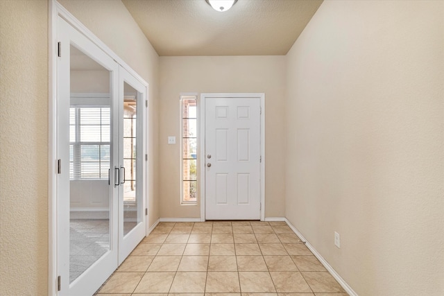 tiled entrance foyer featuring french doors and a textured ceiling