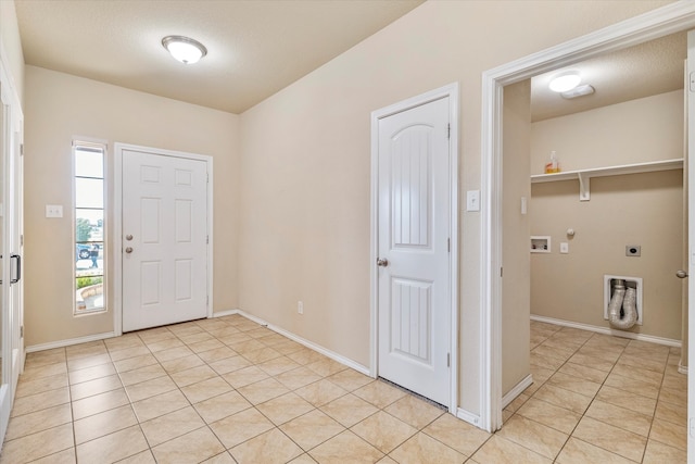 foyer featuring a textured ceiling and light tile patterned floors