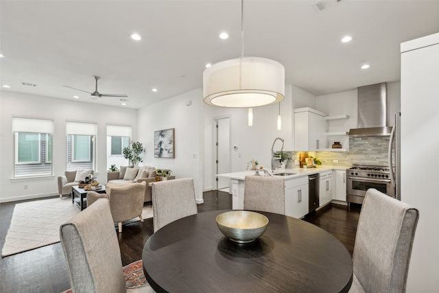 dining space featuring sink, dark wood-type flooring, and ceiling fan