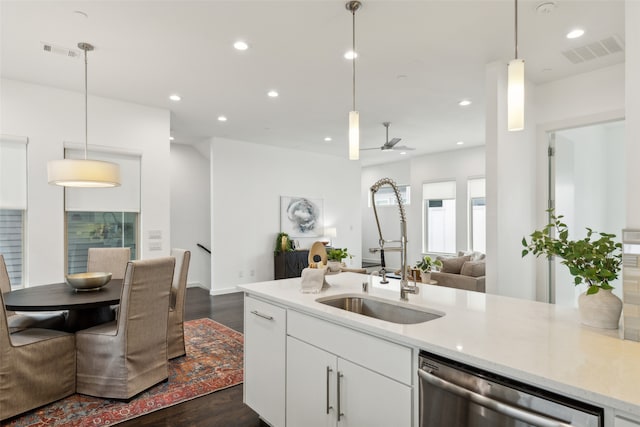 kitchen with white cabinets, stainless steel dishwasher, sink, and decorative light fixtures