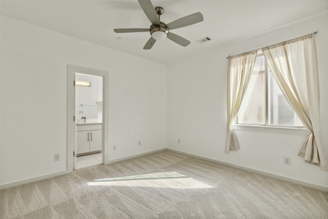 carpeted spare room featuring ceiling fan and sink