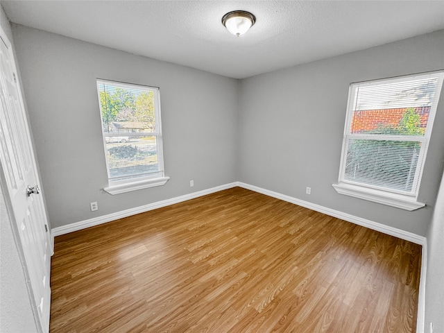 unfurnished room with wood-type flooring and a healthy amount of sunlight