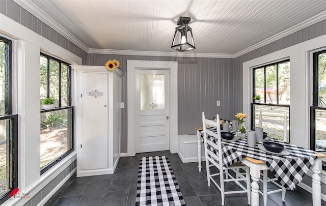 dining space with crown molding, plenty of natural light, and dark tile patterned floors