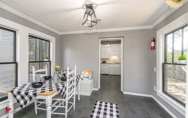 dining room featuring crown molding, sink, and dark tile patterned flooring