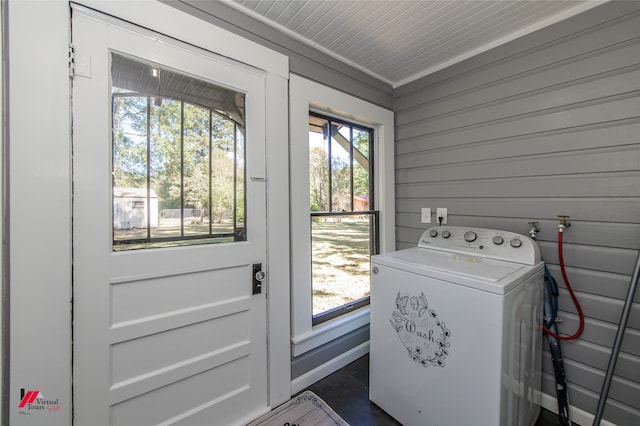 clothes washing area featuring washer / dryer, wood walls, crown molding, and plenty of natural light