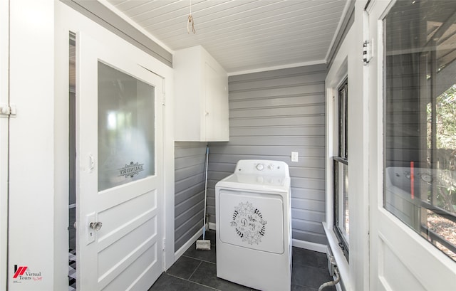 clothes washing area featuring washer / dryer, cabinets, ornamental molding, wood walls, and dark tile patterned flooring