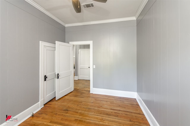 unfurnished room with ornamental molding and light wood-type flooring