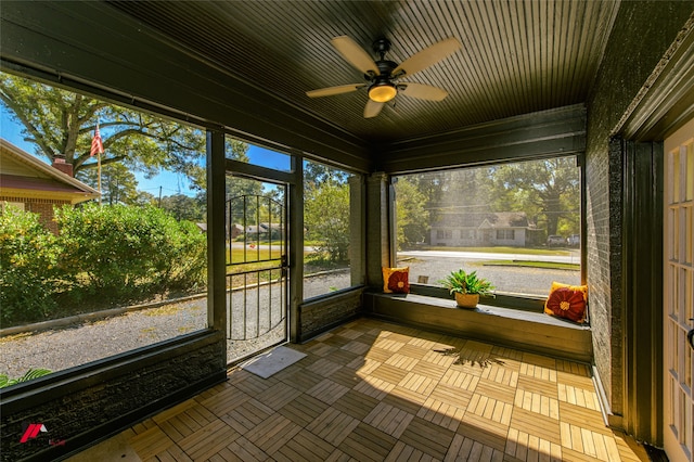 unfurnished sunroom featuring ceiling fan