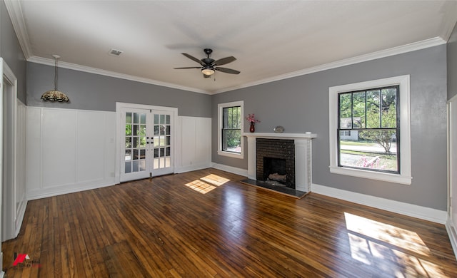 unfurnished living room featuring french doors, dark hardwood / wood-style flooring, a brick fireplace, ceiling fan, and ornamental molding