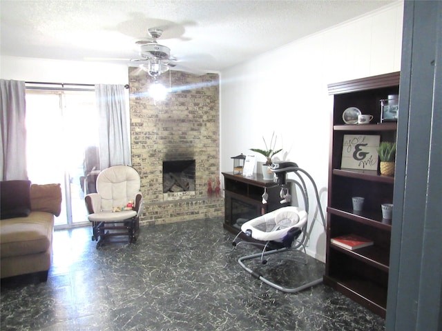 living room with a textured ceiling, ceiling fan, and a brick fireplace